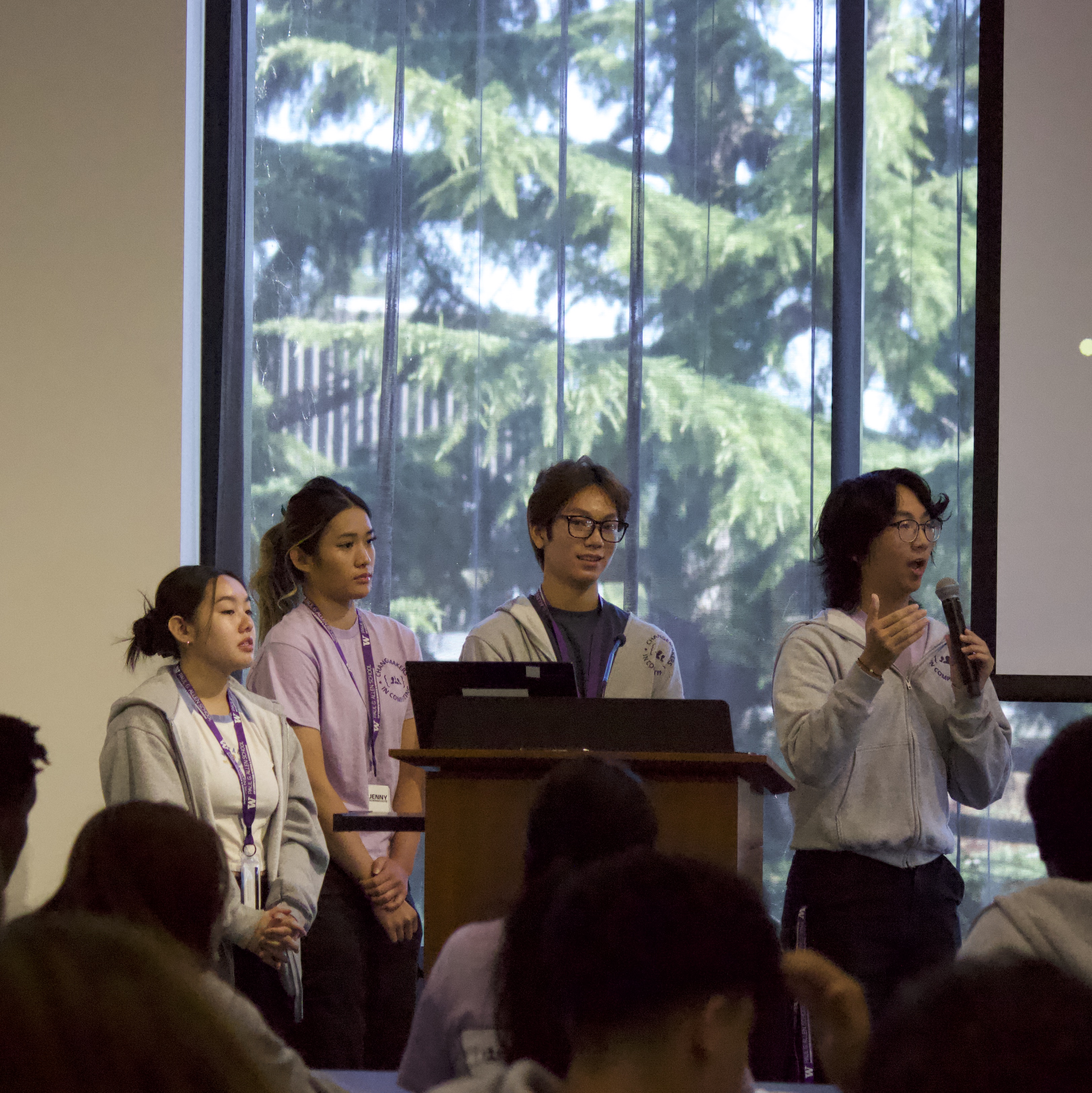 4 students talking with a microphone towards
