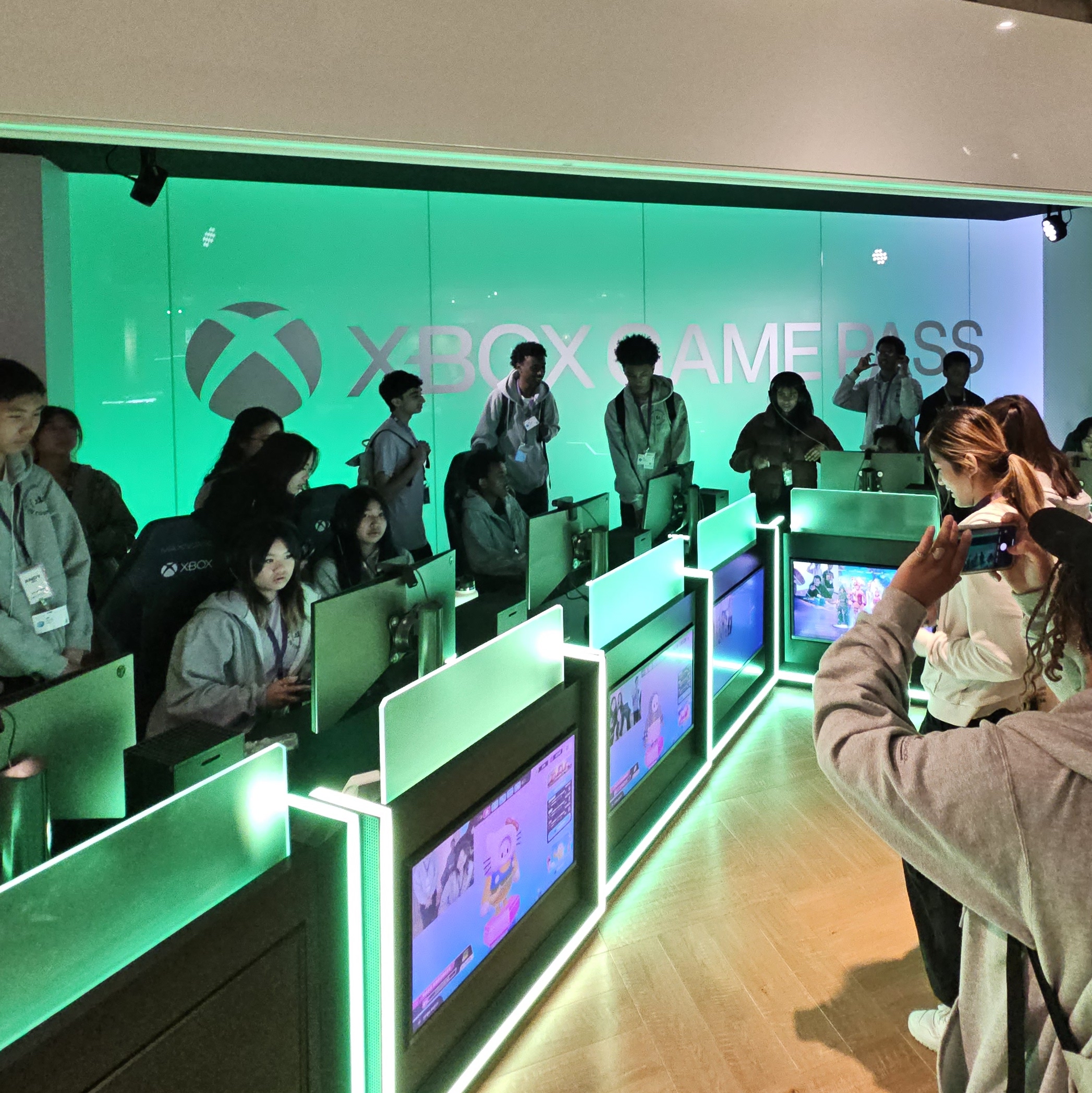 Students sitting down at computers playing games with a small group behind them